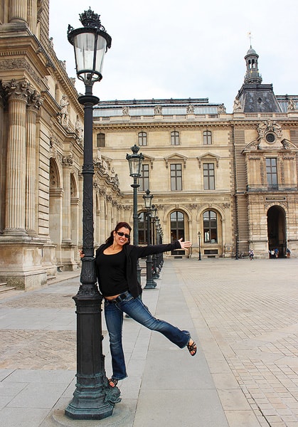 Robyn hanging from a lamp post outside the Louvre Museum in Paris.