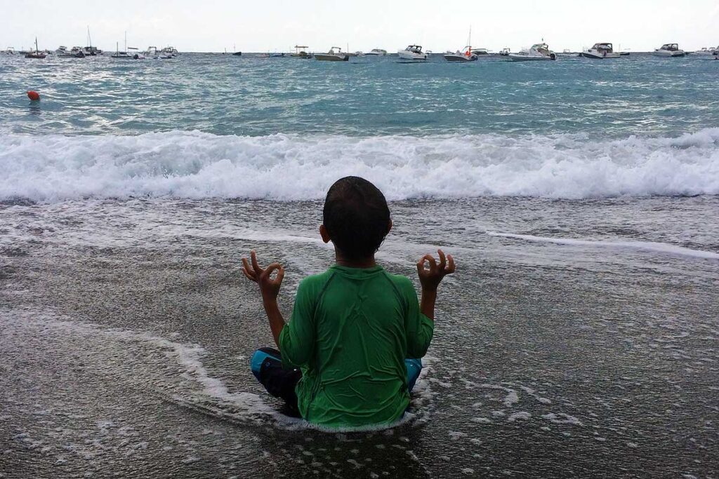 My young nephew in a meditation pose on the beach in Italy. Both yoga and meditation are helpful tools to manage anxiety.