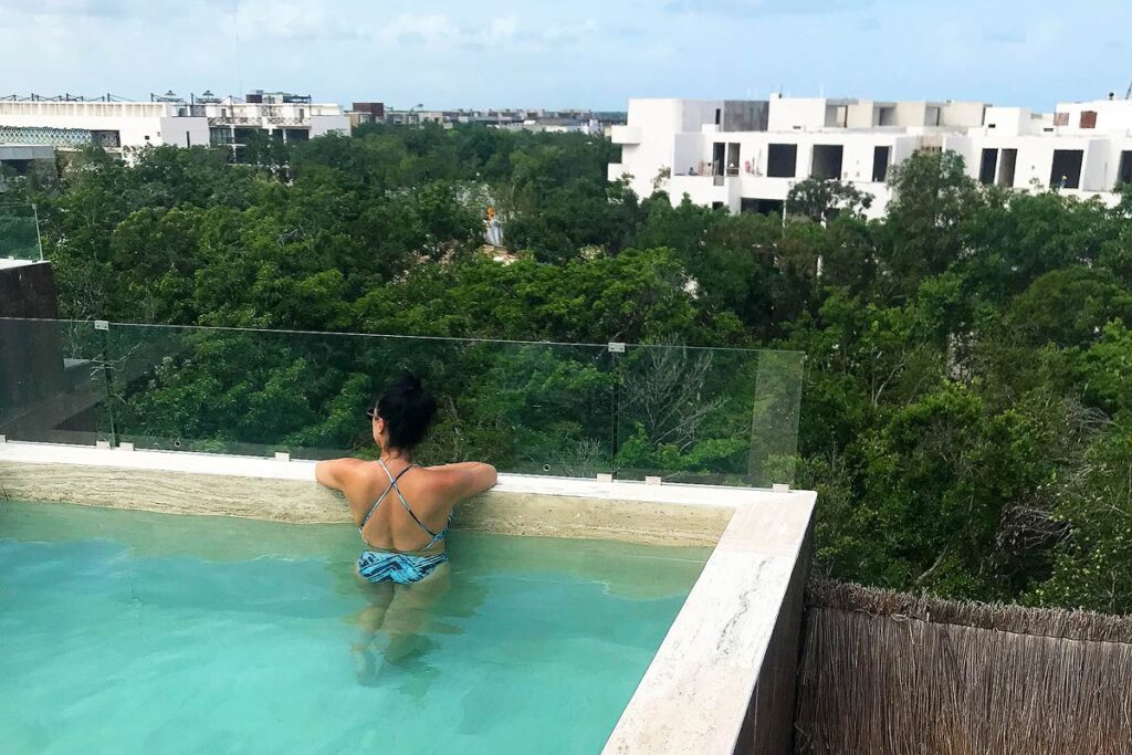 Robyn in a rooftop pool in Tulum, Mexico. Relax and taking care of your mental health.