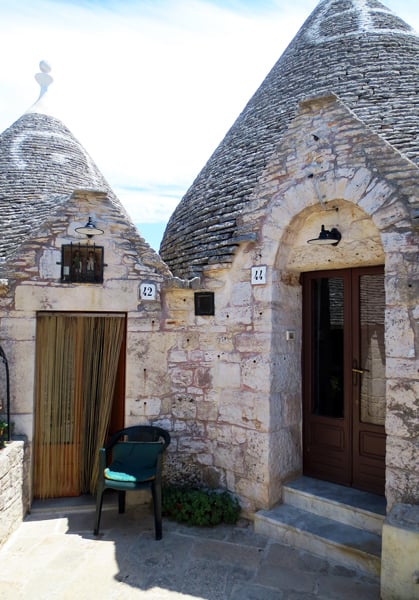 A close up of two trulli houses side by side.