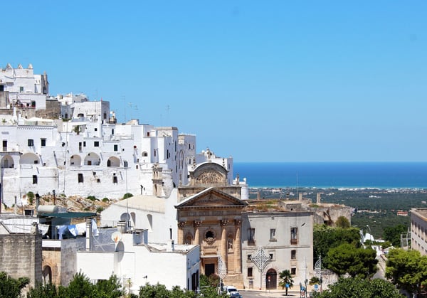 The beautiful hilltop, white washed city of Ostuni with the vibrant blue sea in the distance.