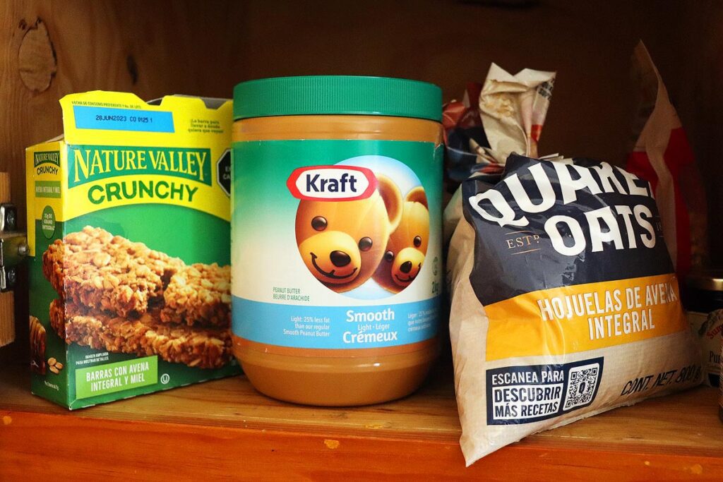 The pantry in our Ajijic apartment stocked with Nature Valley Granola Bars, Kraft Peanut Butter and Quaker Oats. Another great way to spend less on travel is to pack a few essential foods in your luggage.