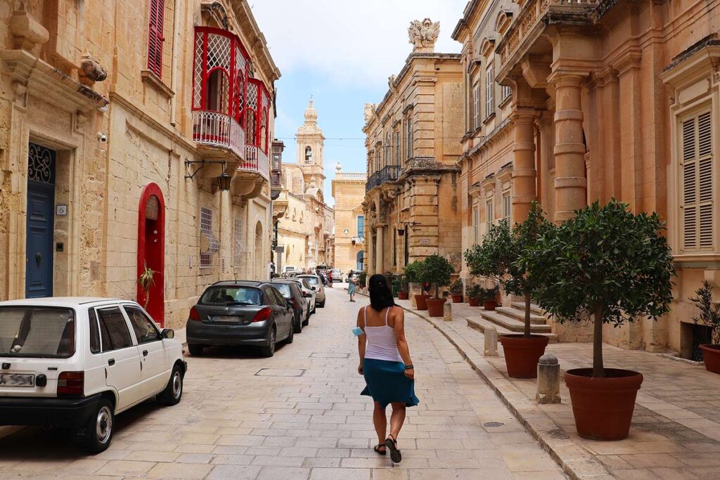 Robyn walking through the towering buildings of Rabat with its colorful shutters
