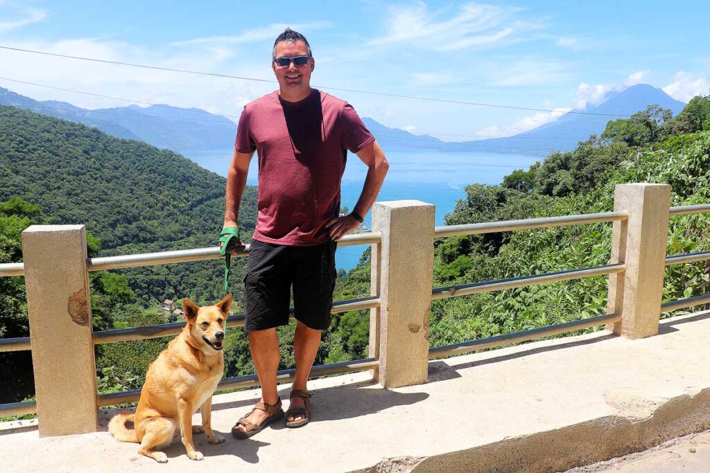 Gavin and our dog Leonardo standing in front of lush green mountains in Guatemala.