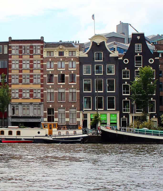 Cute row houses in the classic Dutch design sitting along a quiet canal in Amsterdam.