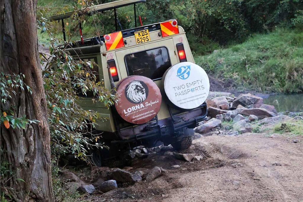 A Lorna Safari & Two Empty Passports safari jeep navigating rocky roads in Masai Mara National Park on our accessible Kenya safari.