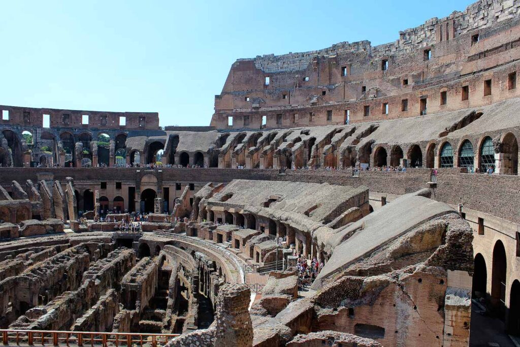 The inside of the Colosseum, one of the top wheelchair accessible attractions in Rome. You can see the ancient tiered stadium and groups of people.