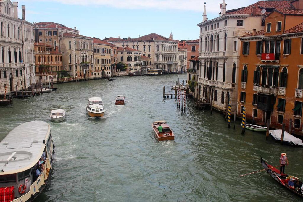 The famous Grand Canal, one of the best things to see during a day trip to Venice. The canal is flanked with colorful buildings and there are several in the water.